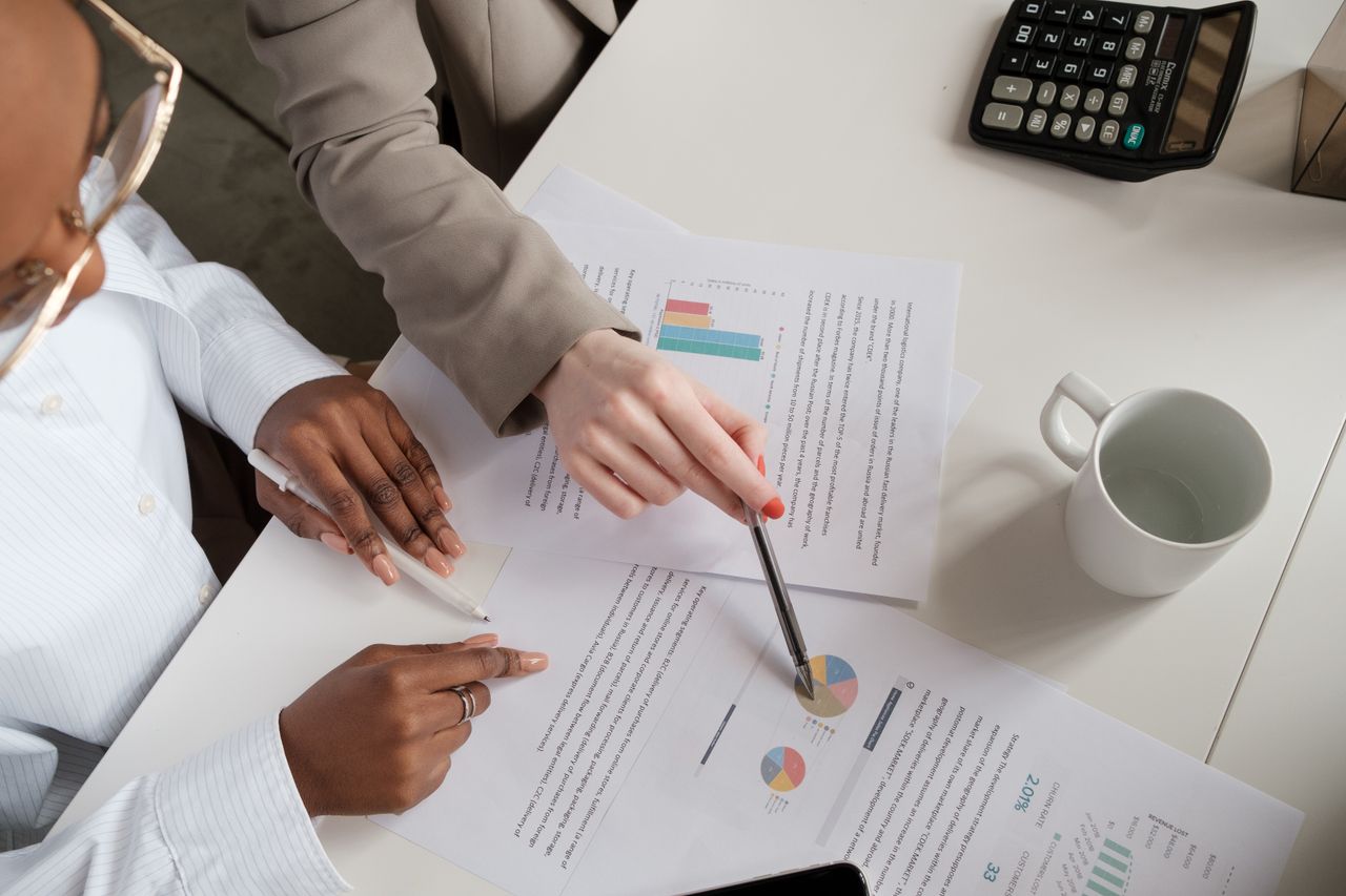 Two professionals discussing charts and data analysis at a business meeting.